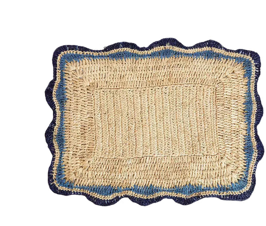A rectangular woven placemat made of natural jute with a scalloped border in navy blue and blue, shown flat on a white background.