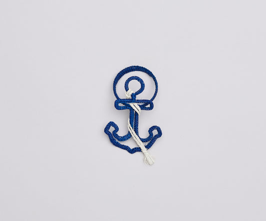Alternating blue and white raffia anchor napkin rings arranged in a row, handcrafted summer or beach house table decor.