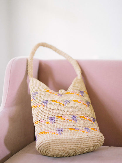 Straw Hobo Bag- Bag on pink sofa- by Payton James Nashville Handbag designer