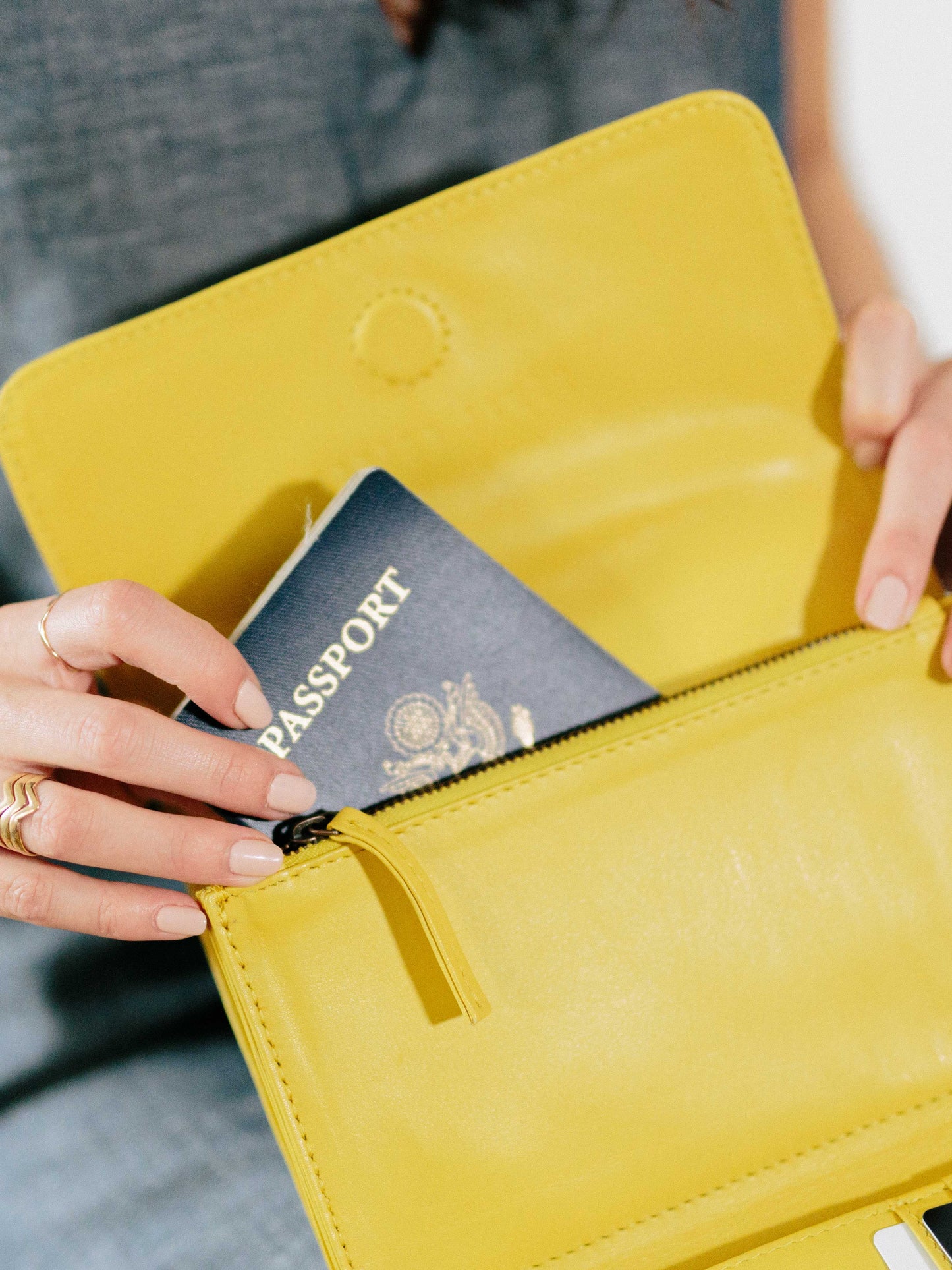 Travel wallet payton james- model holding wallet with passport showing-yellow passport wallet payton James