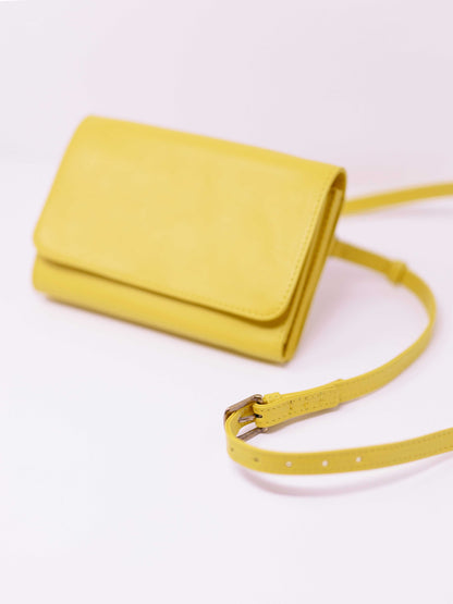 Yellow crossbody travel wallet with strap showng by payton james