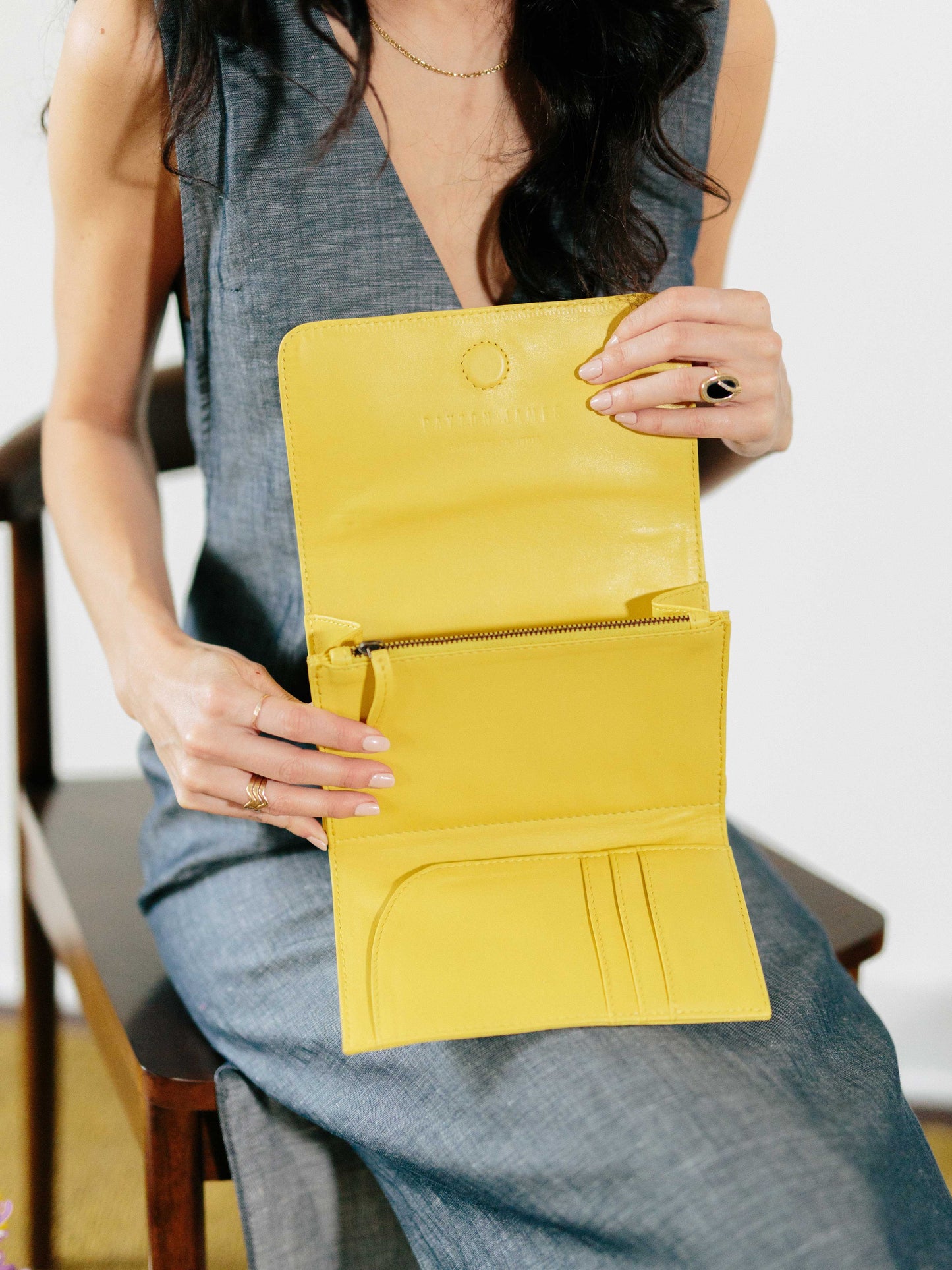 Travel wallet by payton james- model holding the inside of the yellow travel wallet
